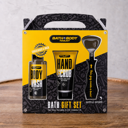 Bath and Body Toolkit gift set with body wash, hand scrub, and bottle opener on a wooden surface.
